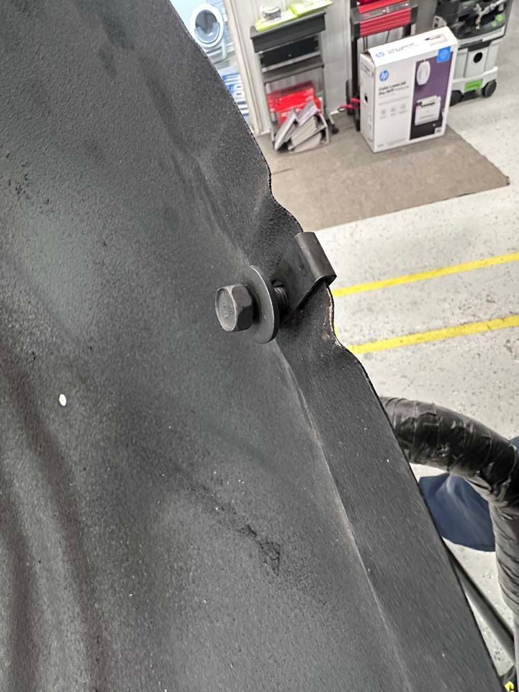 A person is working on a car in a garage.