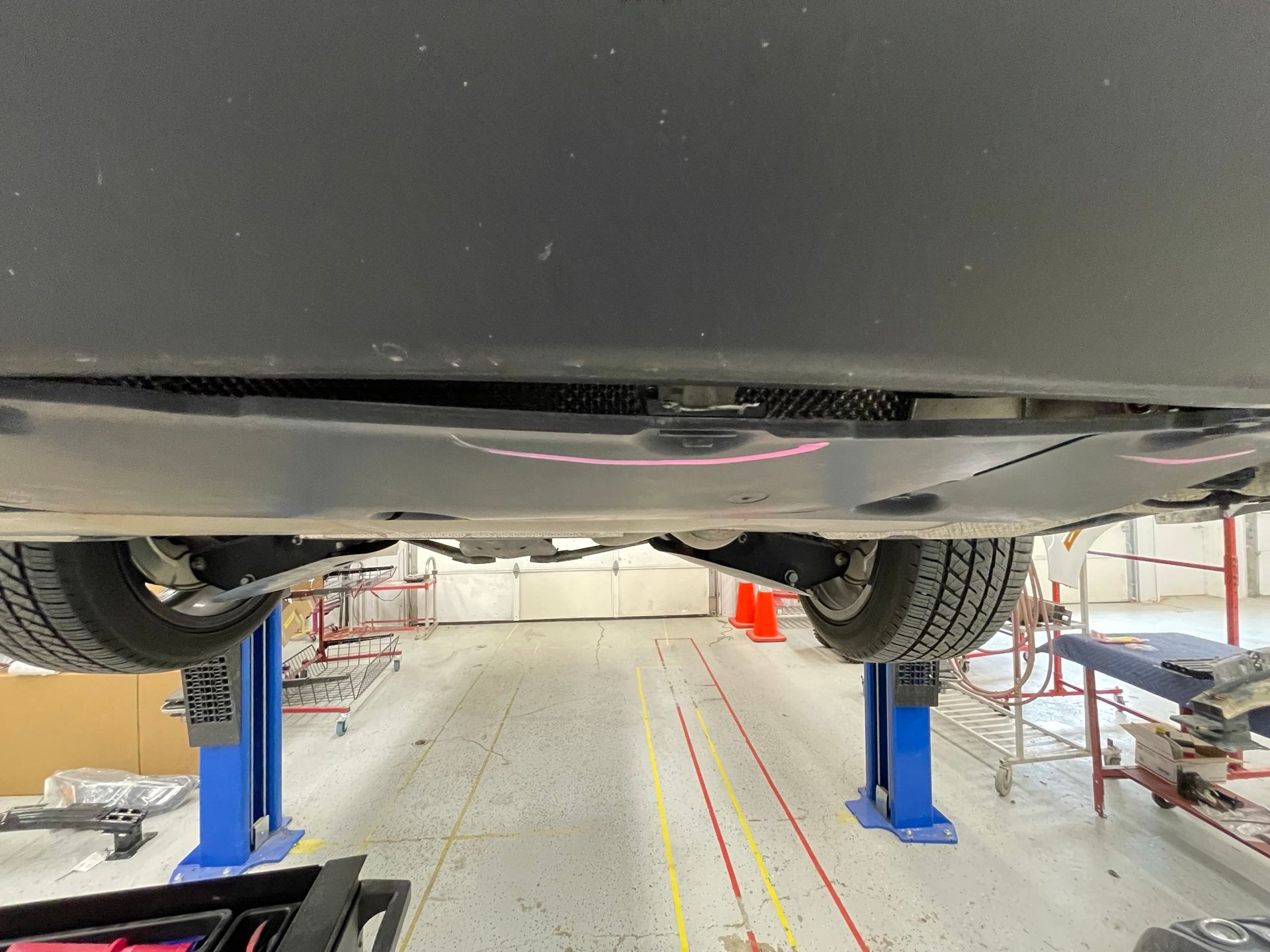 A car is sitting on a lift in a garage.