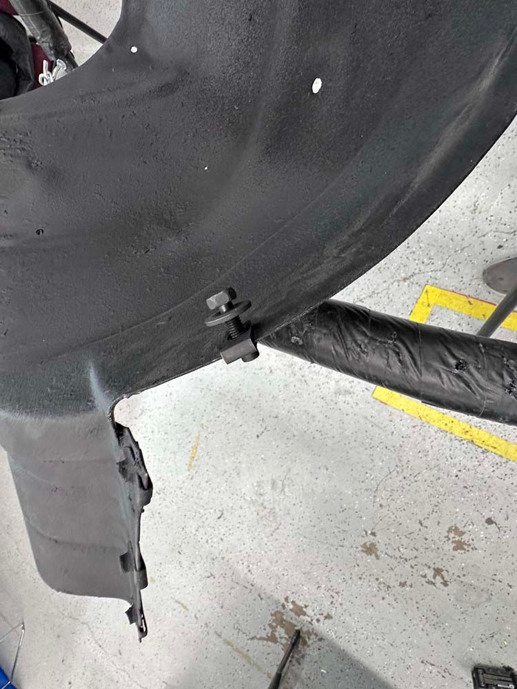 A close up of a motorcycle bumper in a garage.