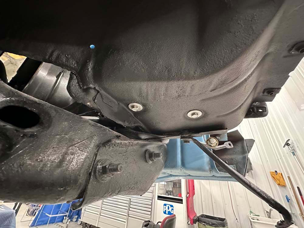 A close up of the underside of a car in a garage.