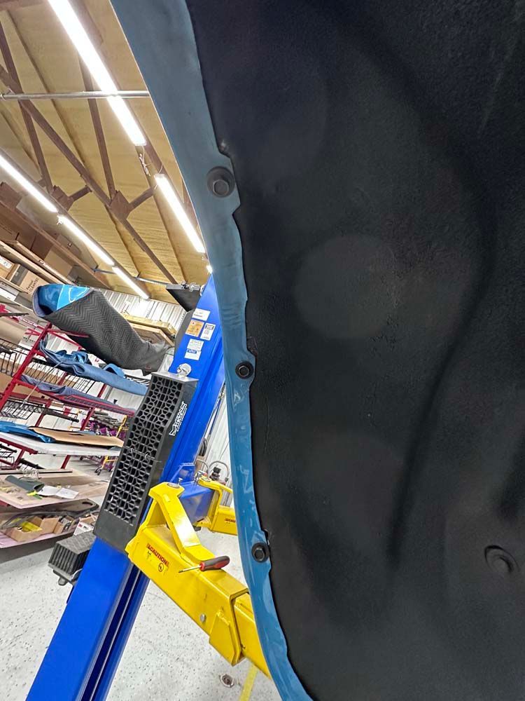 A car is sitting on a lift in a garage.