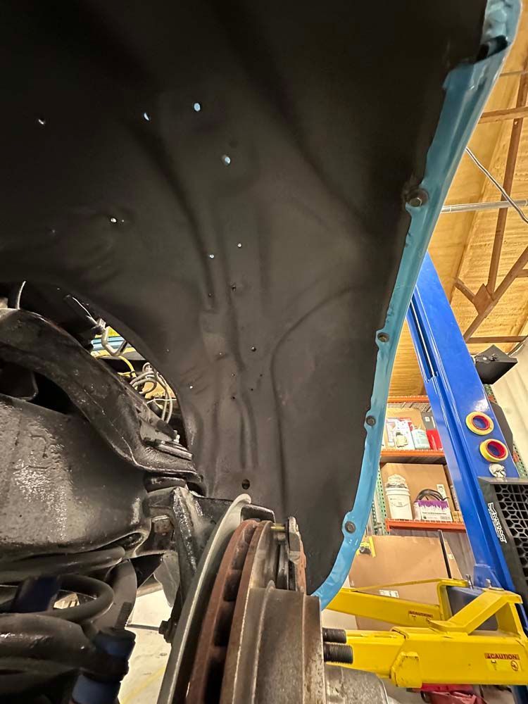 A car is sitting on a lift in a garage.