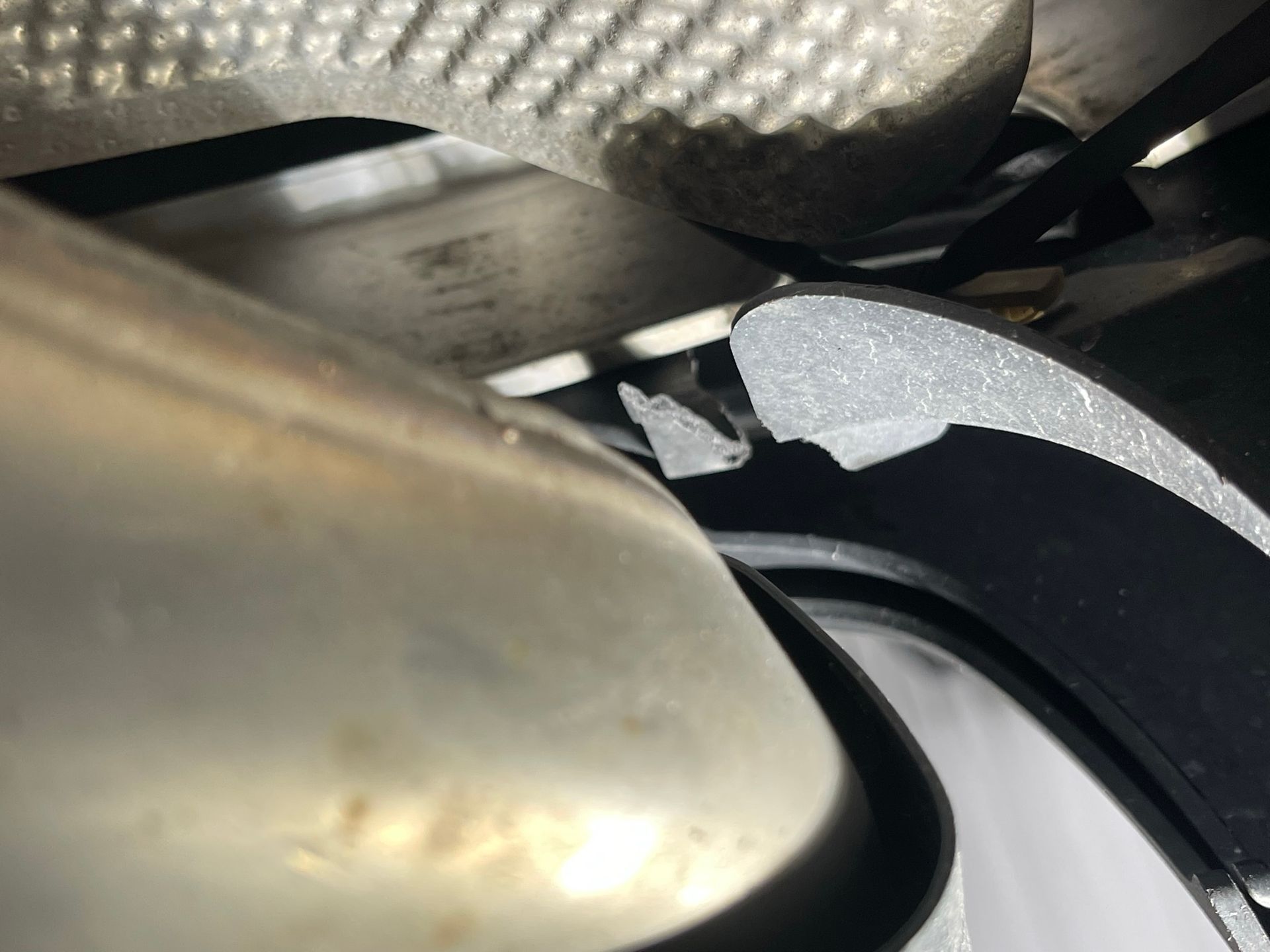 A close up of a stainless steel exhaust pipe on a car.
