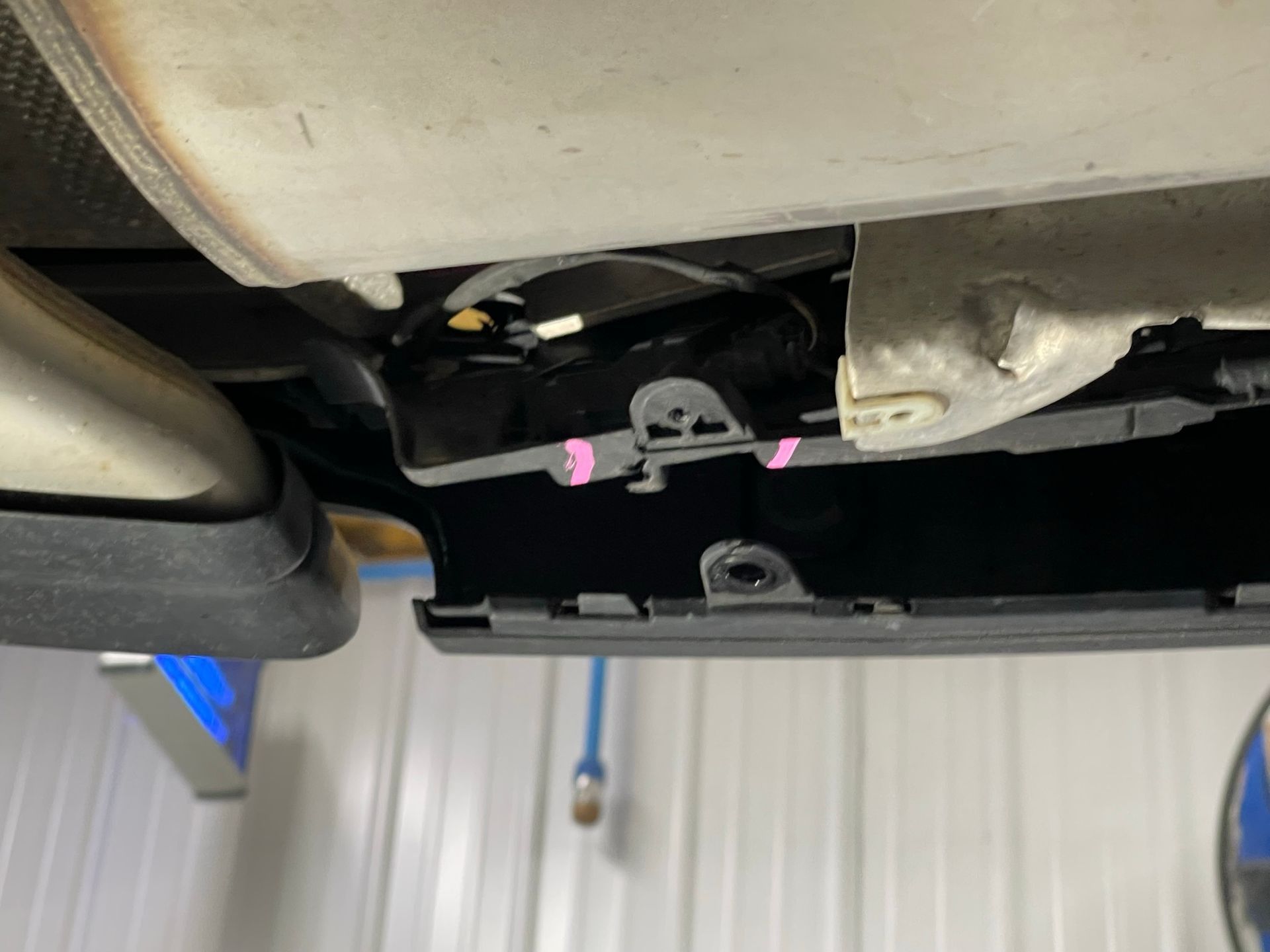 A close up of the underside of a car in a garage.