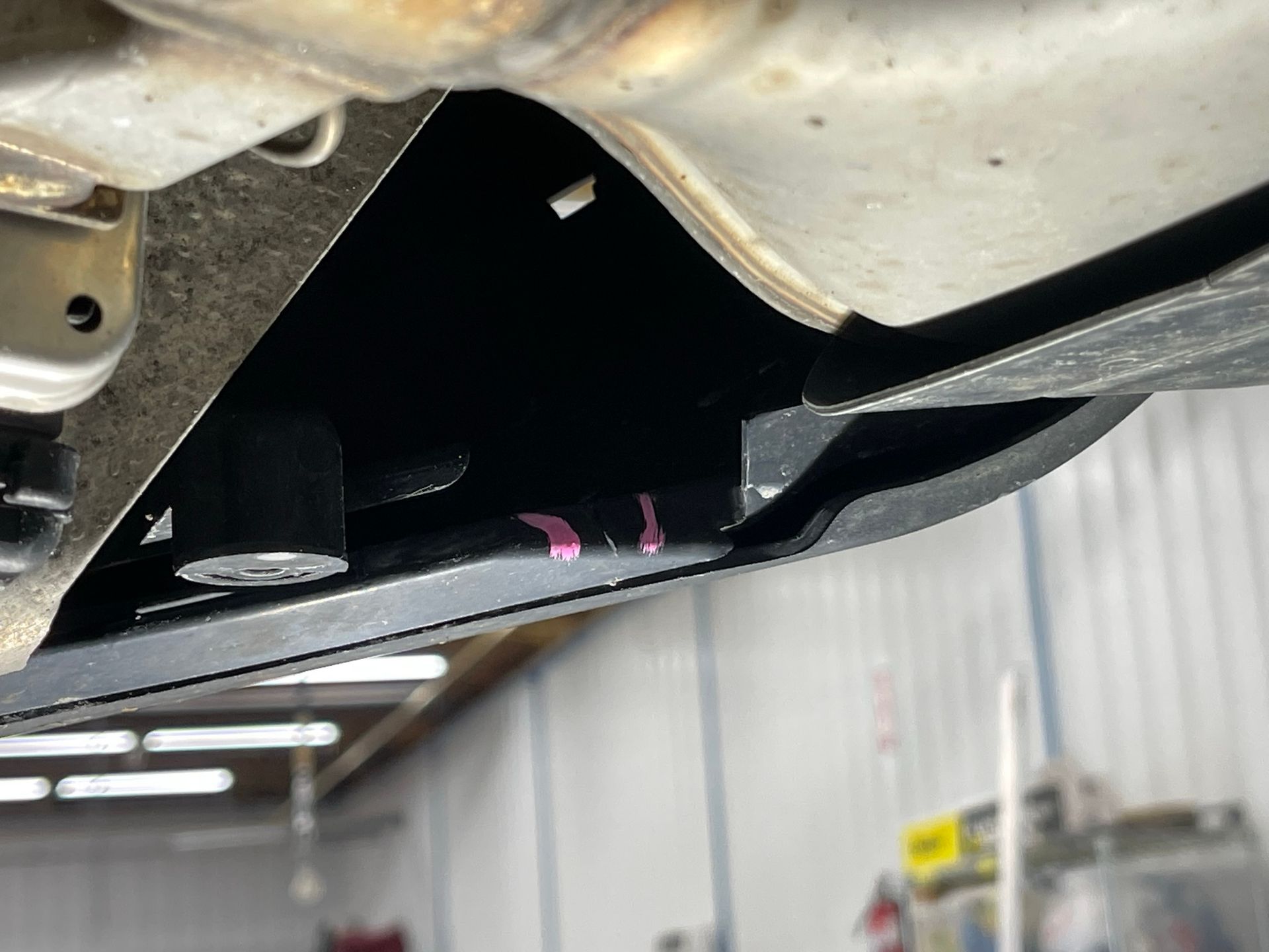 A close up of the underside of a car in a garage.