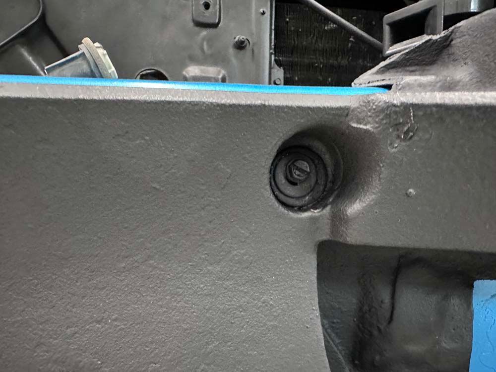 A close up of a car bumper with a blue tape on it.