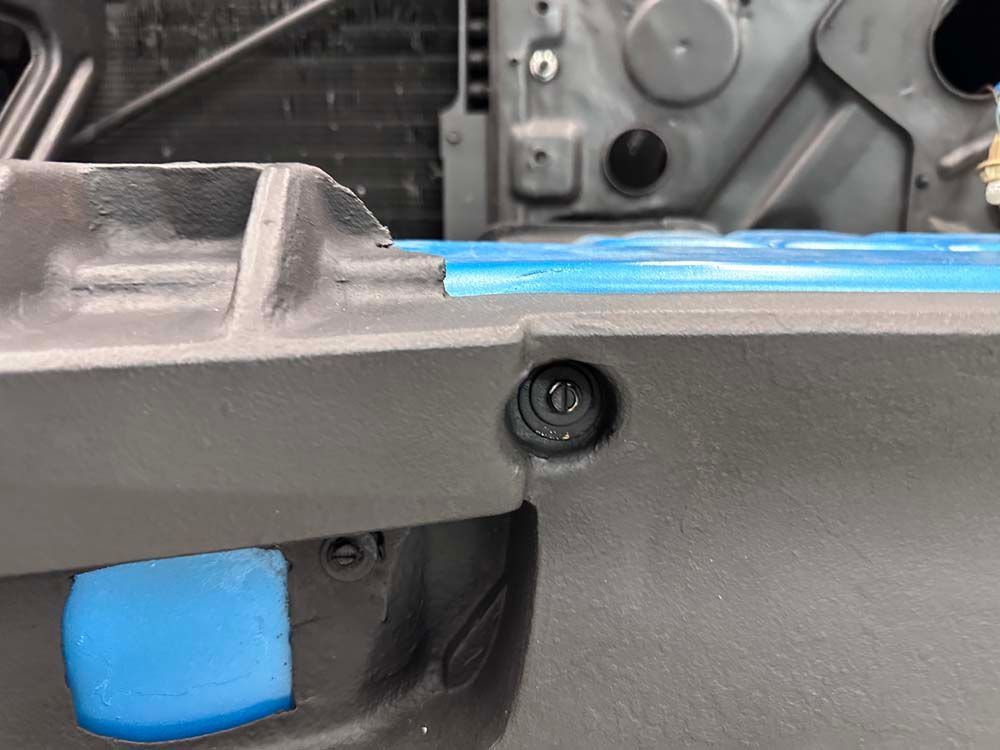 A close up of a car bumper with a blue tape on it.