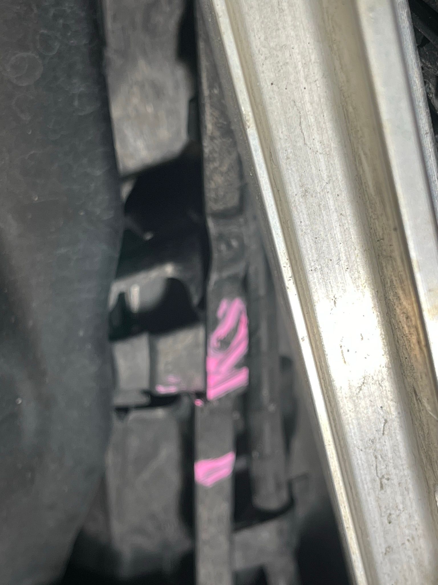 A close up of a piece of metal with pink paint on it.