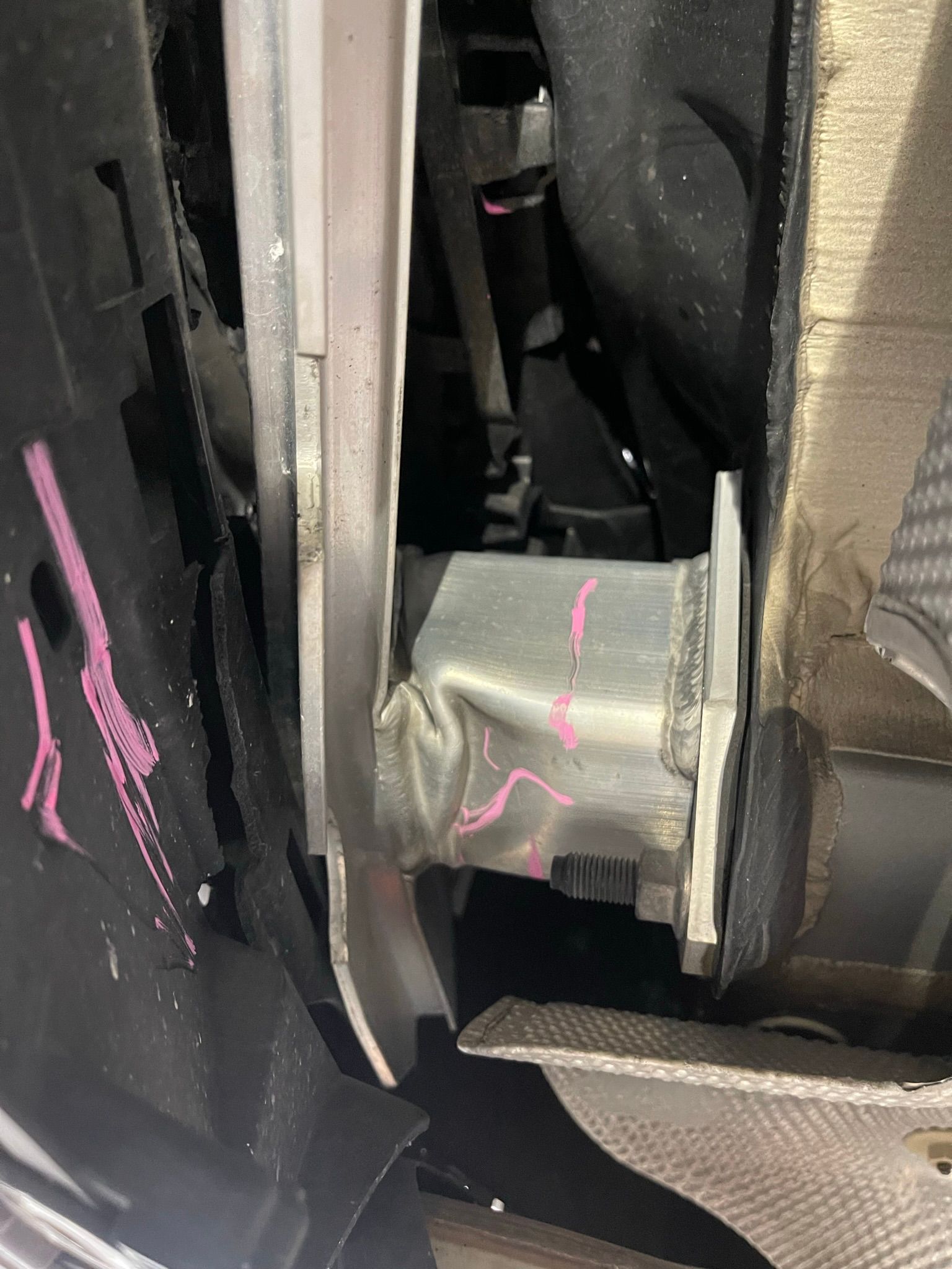 A close up of a metal bracket on the side of a car.