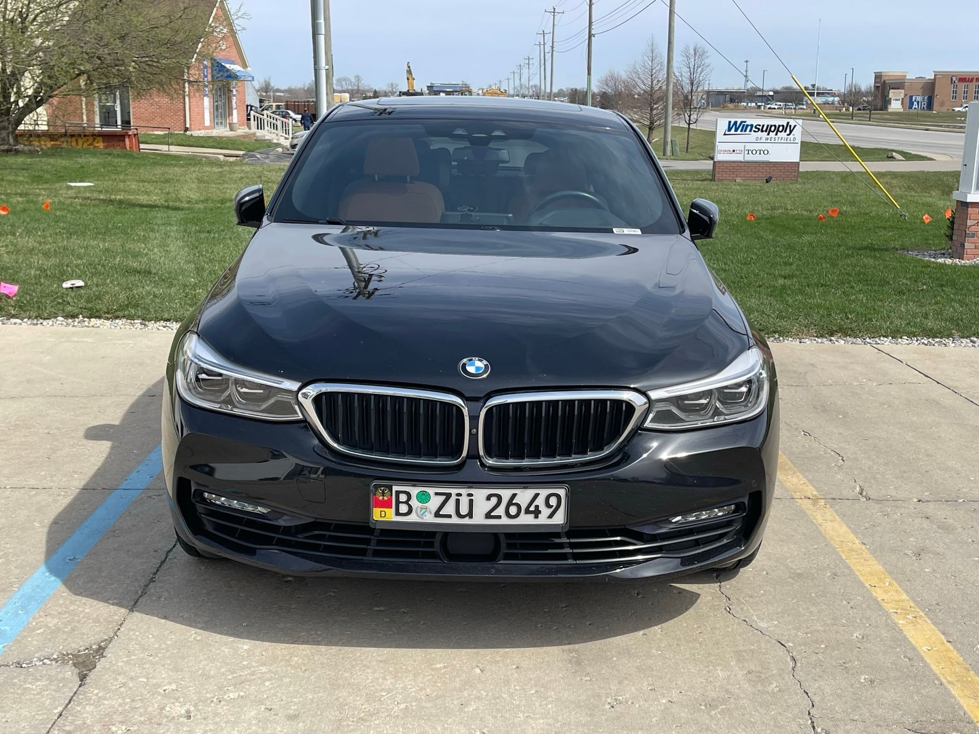 A black bmw with a license plate that says b zu 2649 is parked in a parking lot.