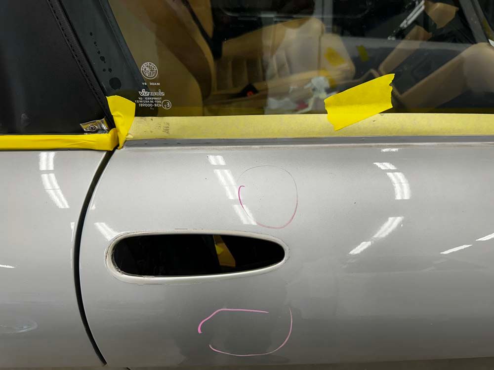 A close up of a car door with yellow tape on it.