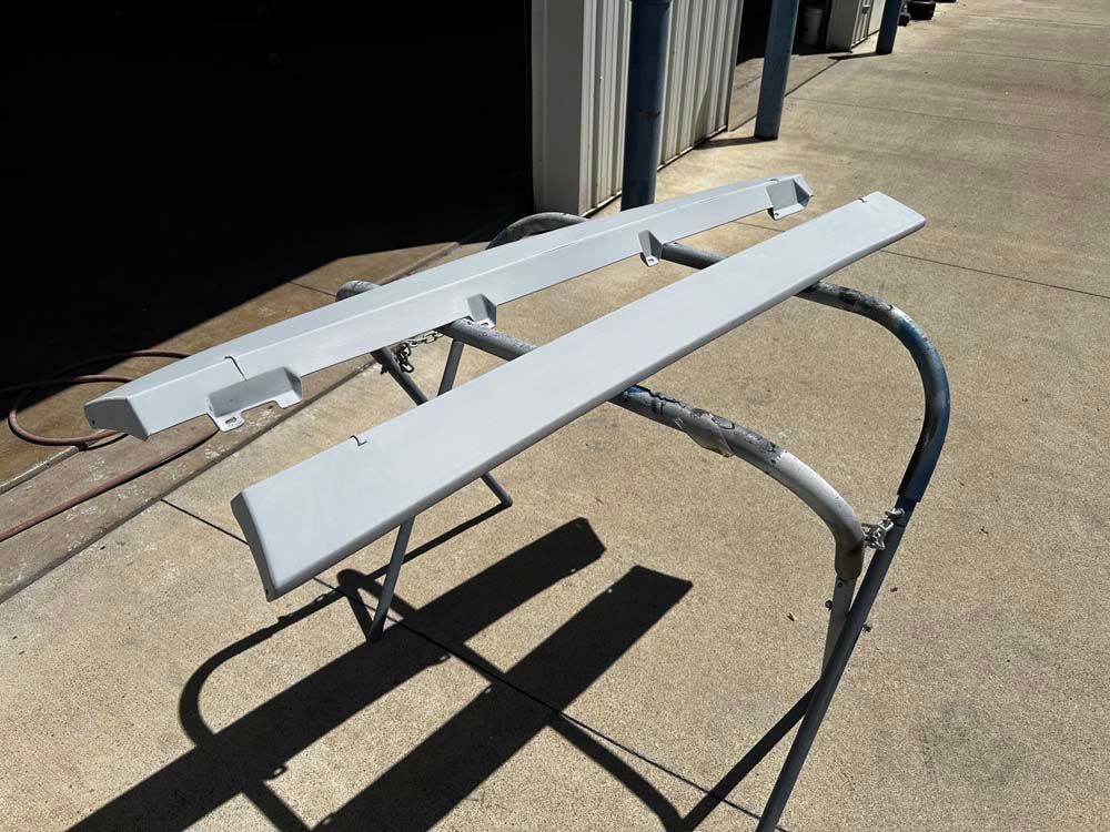 Two white pieces of metal are sitting on top of a concrete surface.