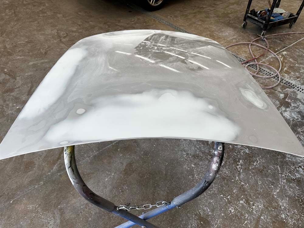 A white hood is sitting on top of a metal stand.