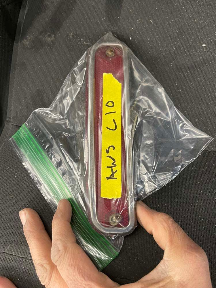 A person is holding a plastic bag with aw5 610 written on it