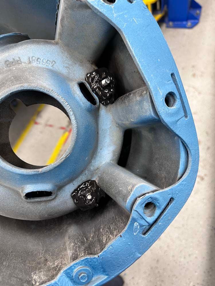 A close up of a blue metal object with a hole in the middle.