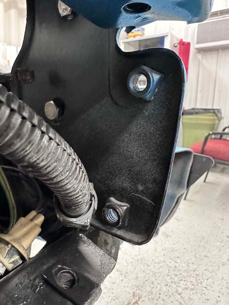 A close up of a piece of metal with a hose attached to it.