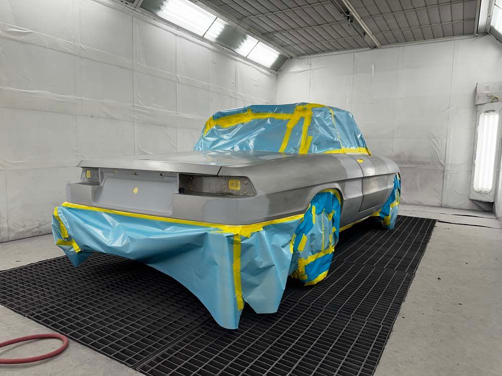 A car is being painted in a paint booth.