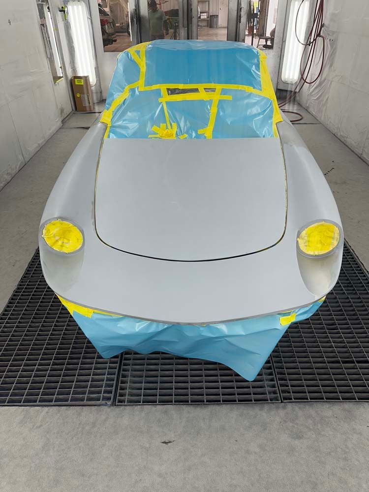 A car is being painted in a paint booth.