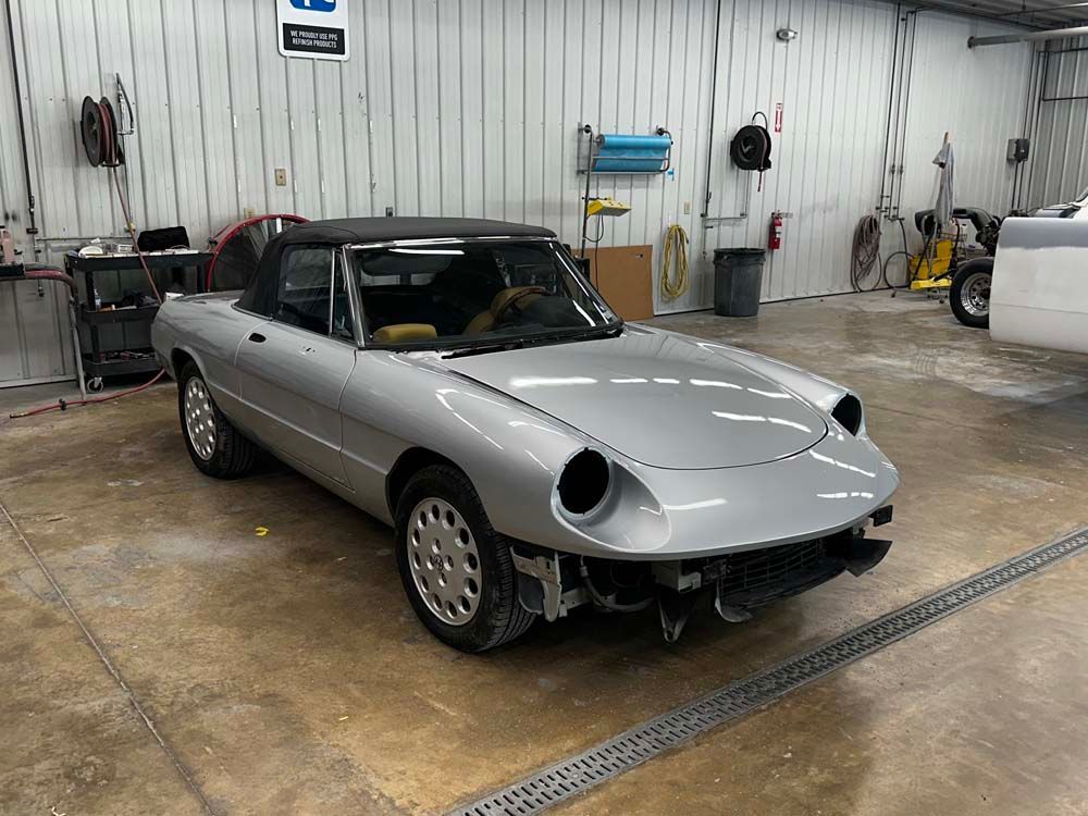 A silver sports car is parked in a garage.