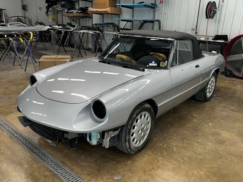 A silver sports car is parked in a garage.