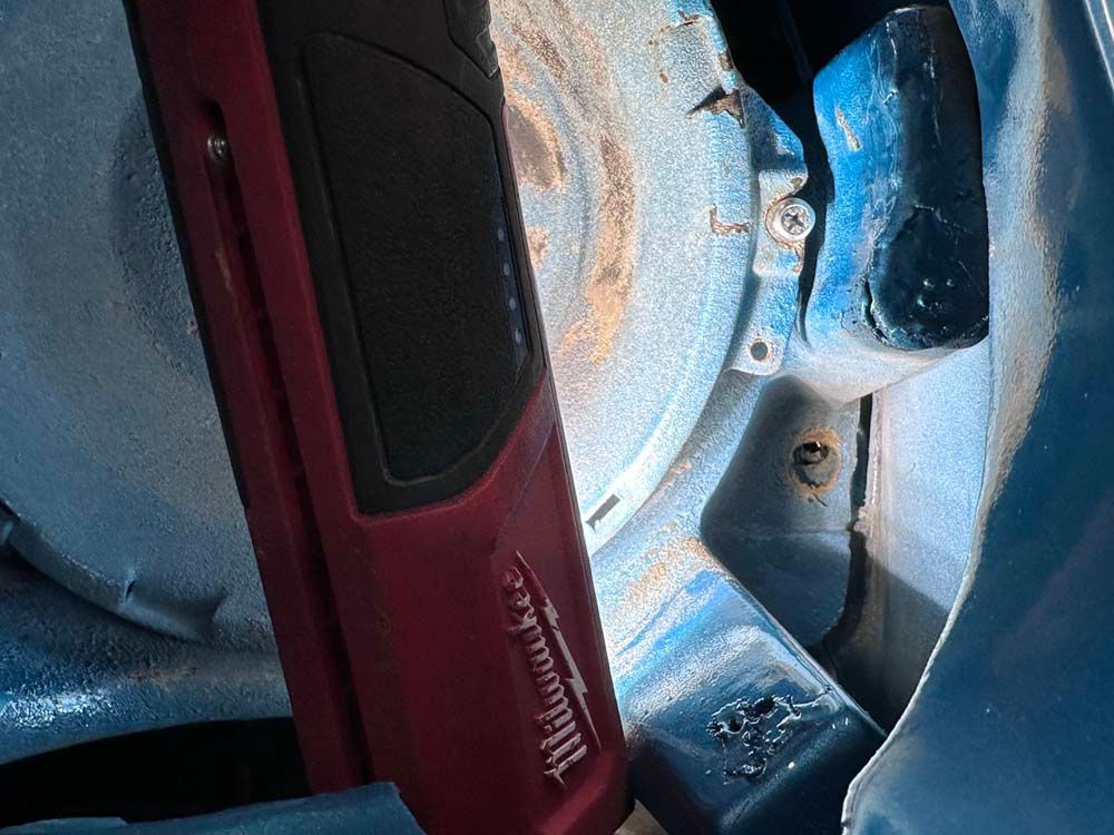 A red milwaukee tool is sitting inside of a blue car.