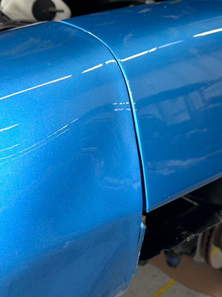 A blue car is sitting on a table in a garage