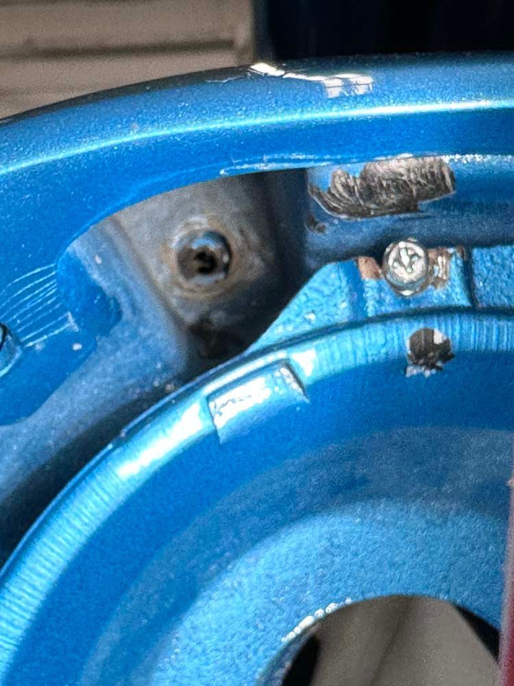 A close up of a blue wheel with a screw in it.