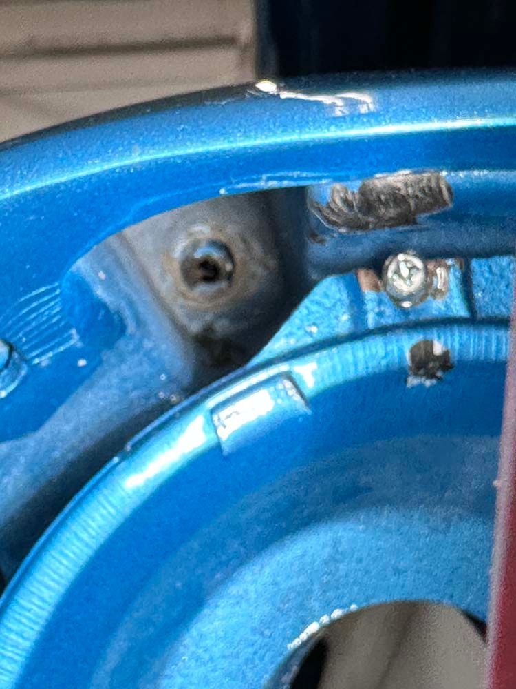 A close up of a blue wheel with a screw in it.