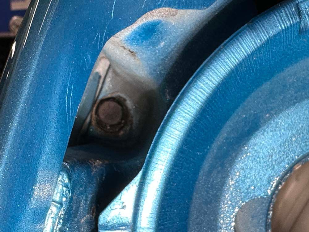 A close up of a blue wheel with a screw in it