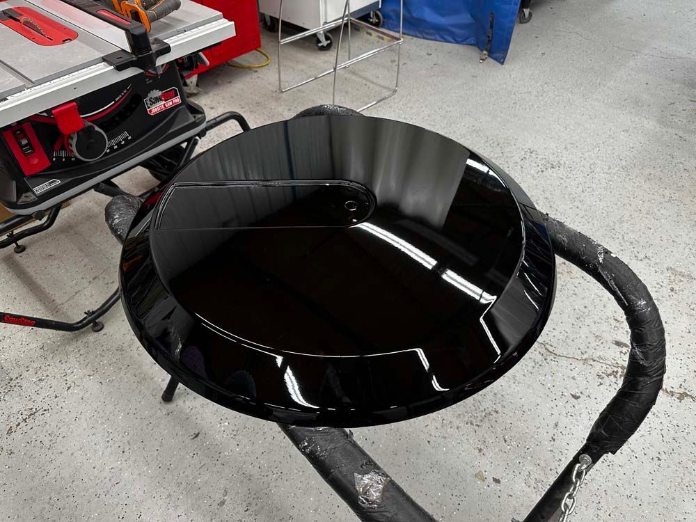 A black bowl is sitting on a table next to a table saw.