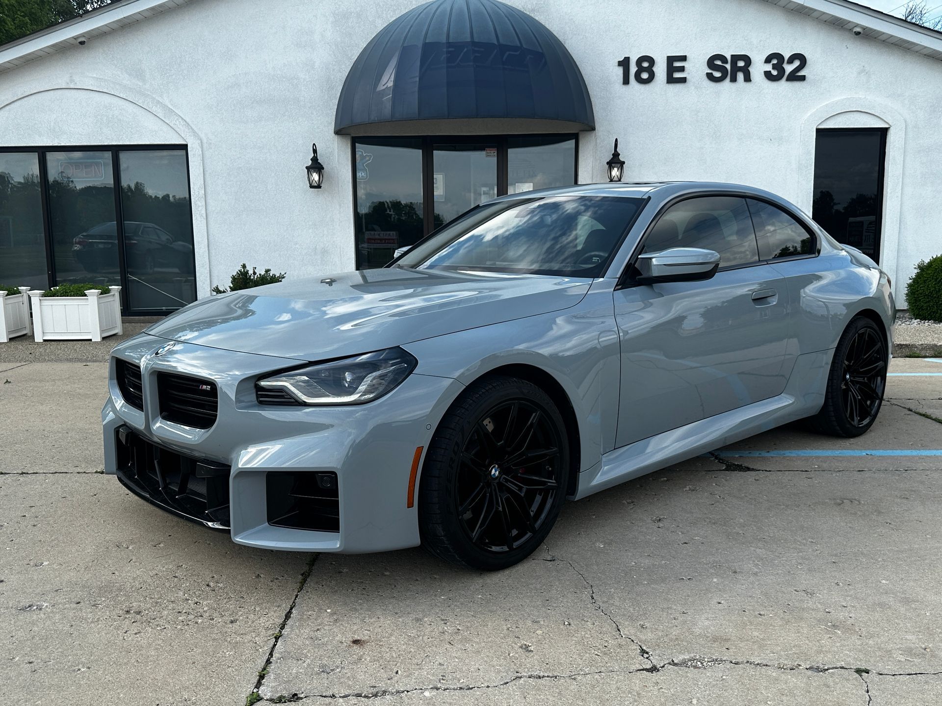 Gray BMW coupe parked in front of a building with a dark blue dome and the address 18 E SR 32.