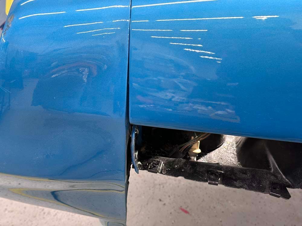A close up of a blue car with chrome trim