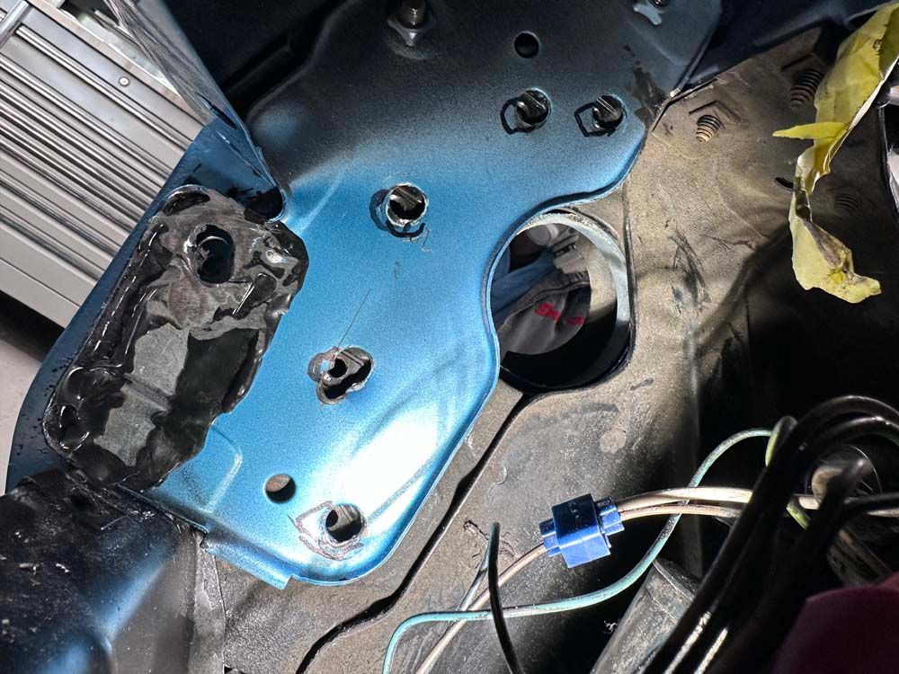 A close up of a blue car with wires coming out of it