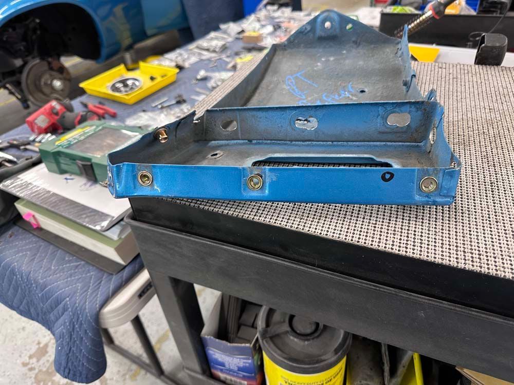 A blue battery tray is sitting on top of a table.