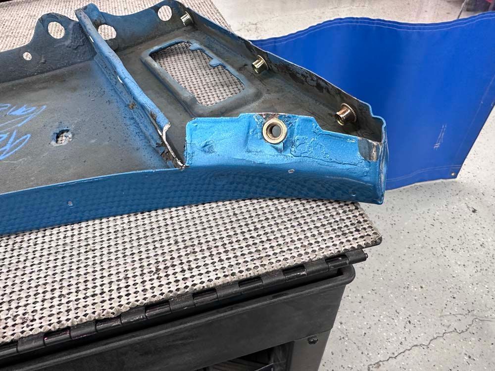 A blue piece of metal is sitting on top of a black box.