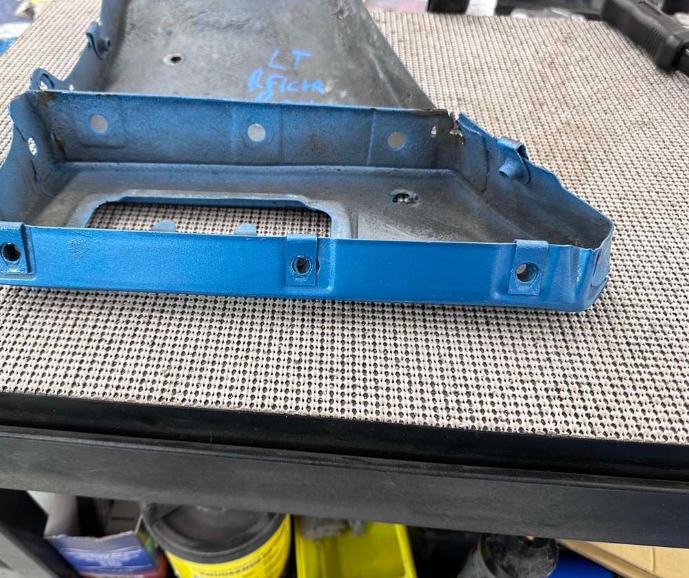 A blue battery tray is sitting on top of a shelf.