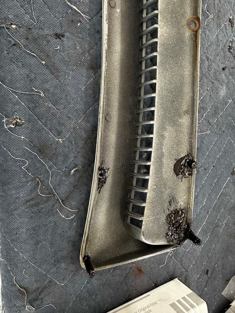 A piece of metal is sitting on a table next to a box.