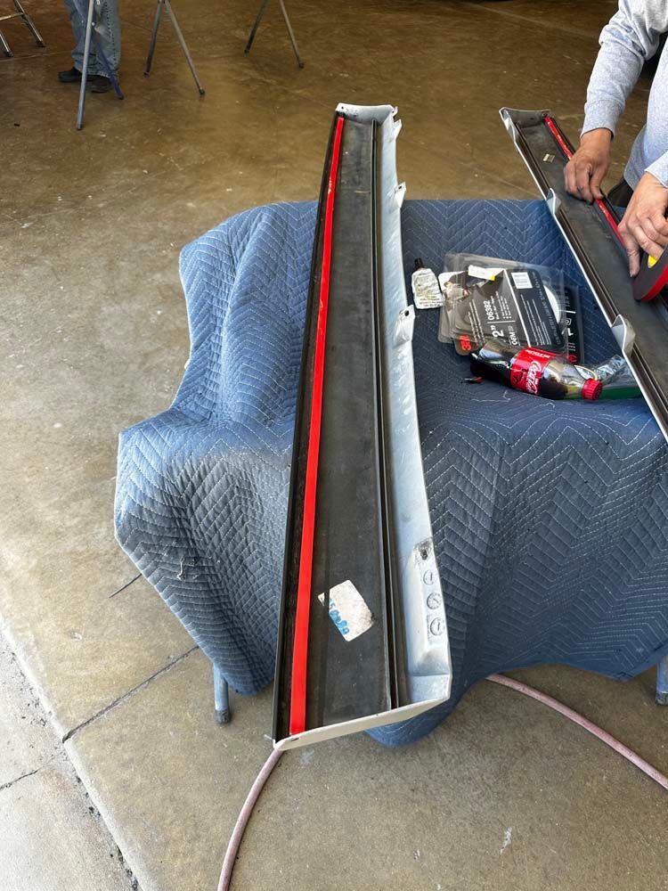 A person is working on a piece of metal on a table