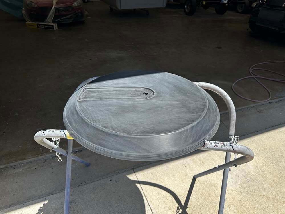 A metal object is sitting on top of a metal stand on the sidewalk.