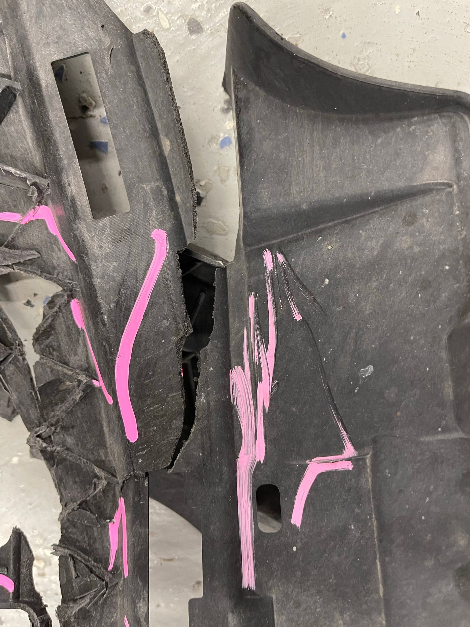 A close up of a broken piece of plastic with pink paint on it.