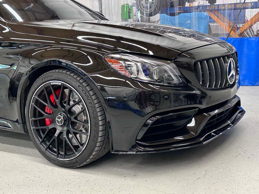 A black mercedes benz sl63 amg is parked in a garage.