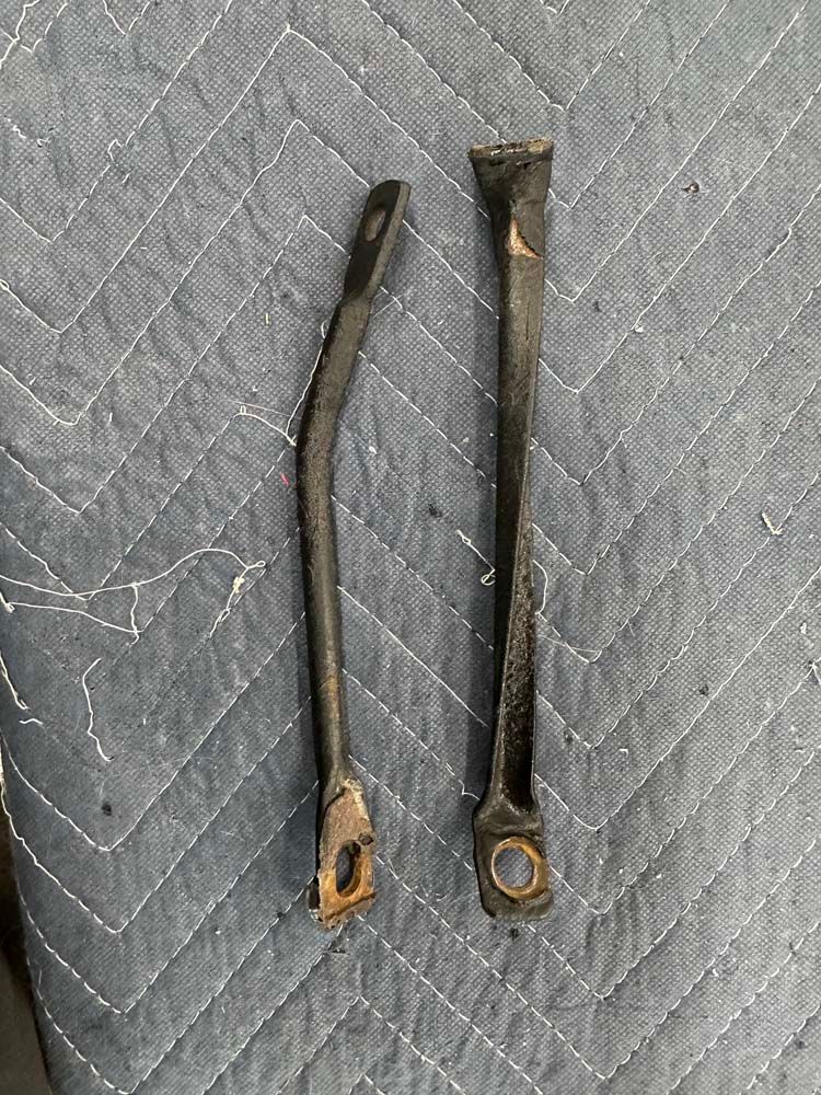 A pair of metal handles are sitting on top of a quilted blanket.