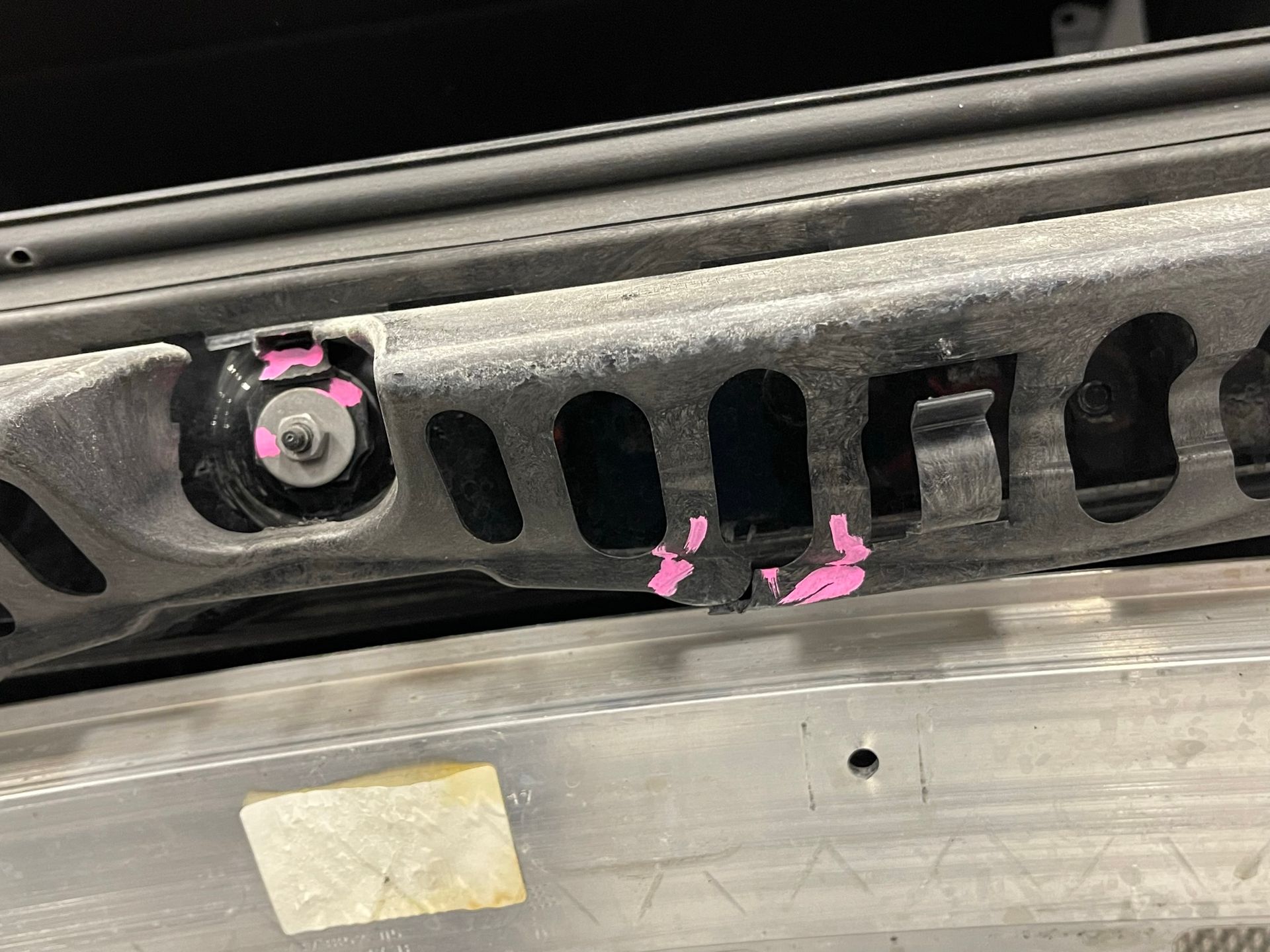 A close up of a piece of metal with pink paint on it.