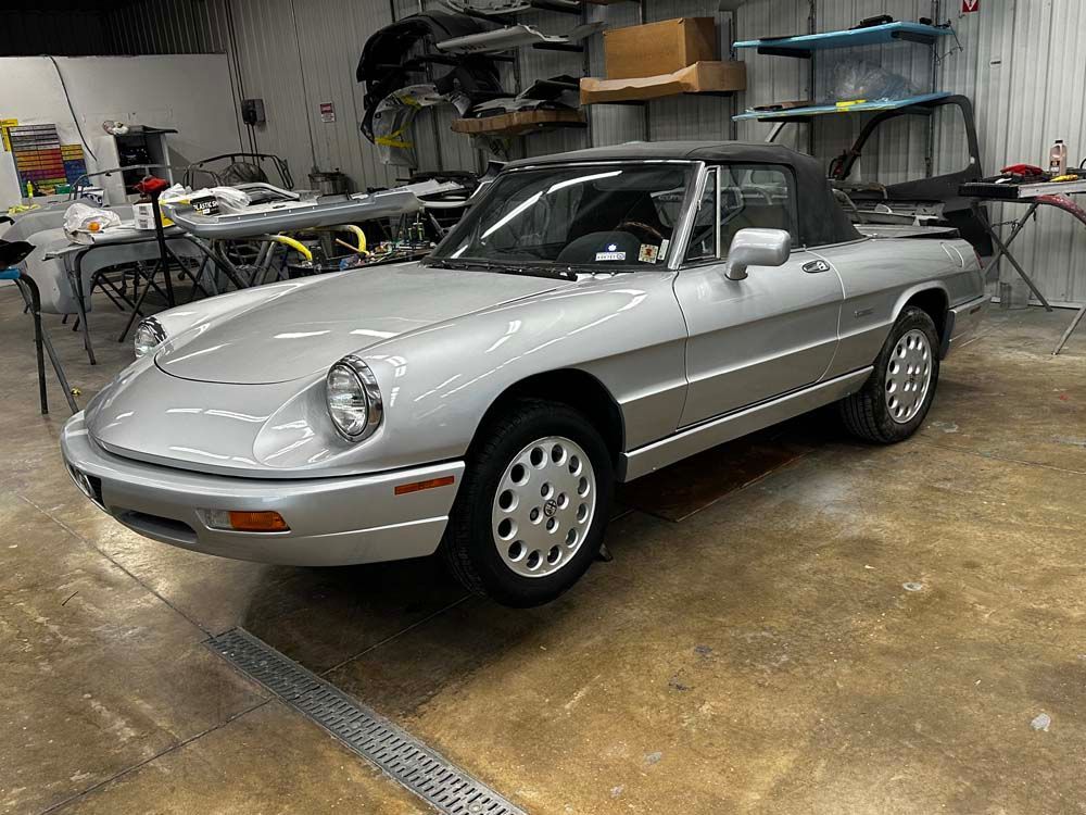 A silver sports car is parked in a garage.