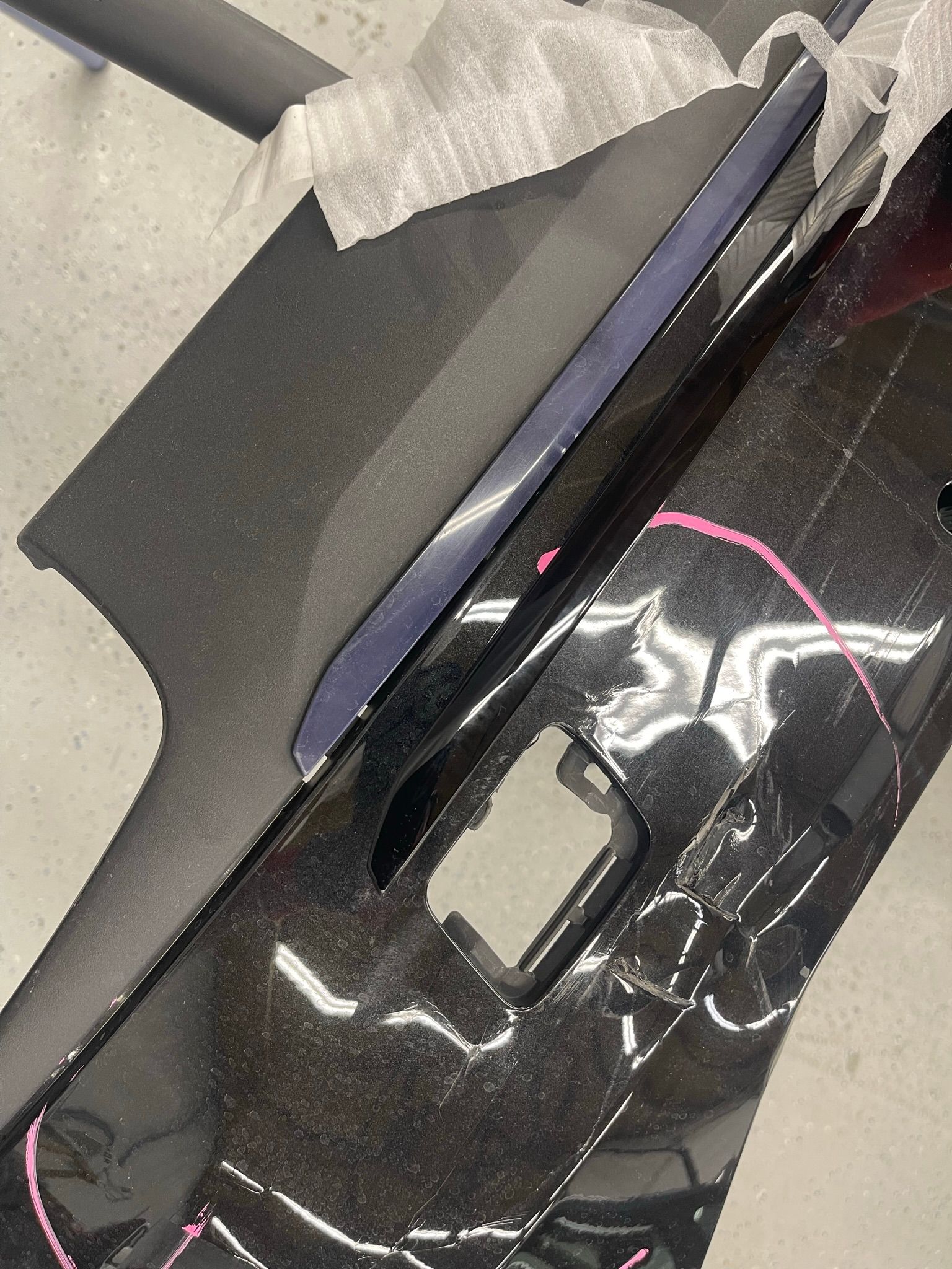 A close up of a black car door with a hole in it