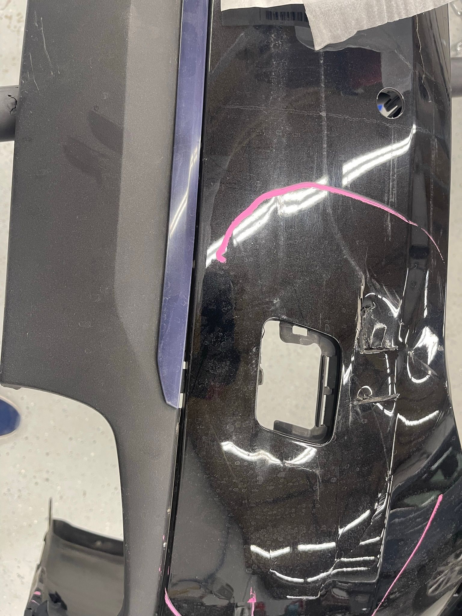 A close up of a black bumper with a hole in it