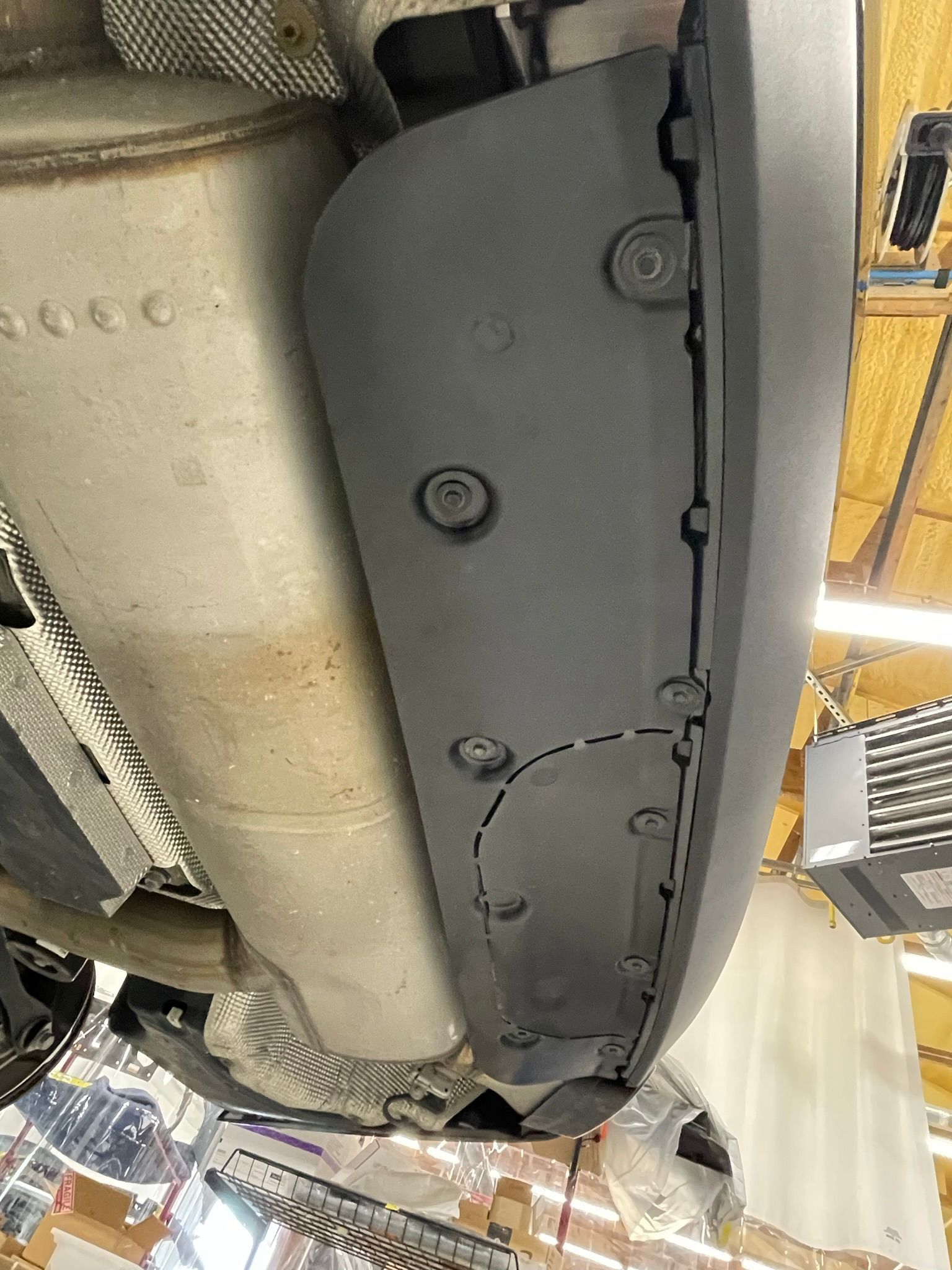 A close up of the underside of a car in a garage.