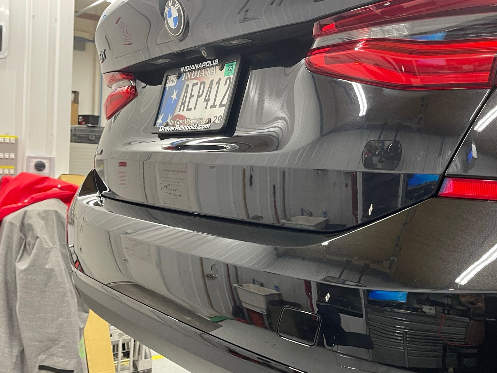 A black bmw is parked on a lift in a garage.