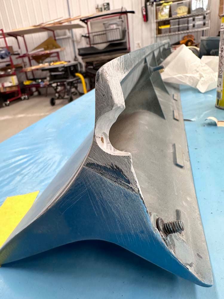 A piece of metal is sitting on top of a blue table.