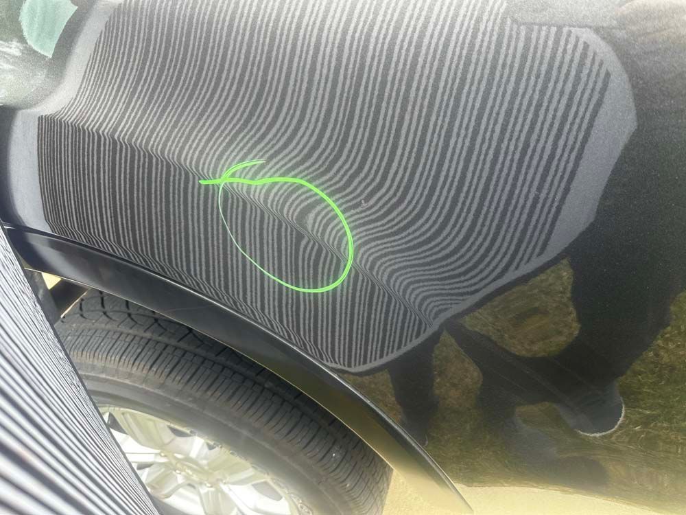 A close up of a black car with a green circle around it.